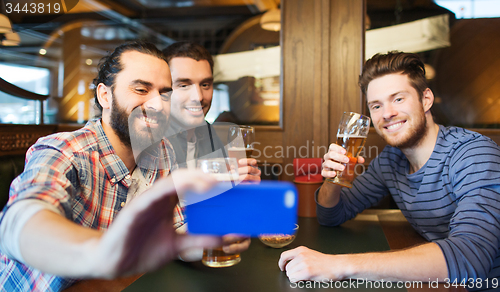 Image of male friends with smartphone drinking beer at bar