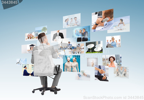 Image of businessman sitting in office chair from back