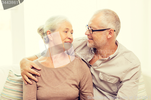 Image of happy senior couple hugging on sofa at home