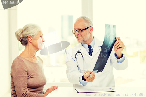 Image of smiling senior woman and doctor meeting