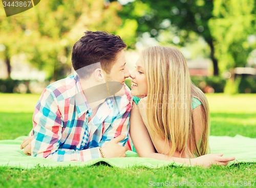 Image of smiling couple lying on blanket in park