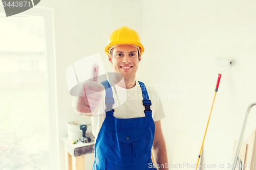 Image of smiling young builder in hardhat showing thumbs up
