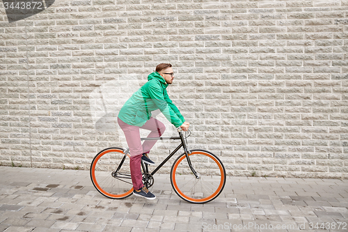 Image of young hipster man riding fixed gear bike
