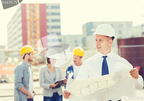 Image of group of builders with tablet pc and blueprint