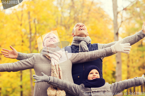 Image of happy family having fun in autumn park