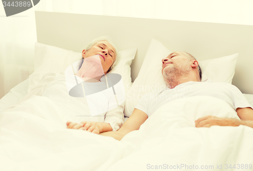 Image of happy senior coupler lying in bad at home