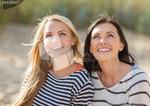 Image of happy teenage girls or young women on beach