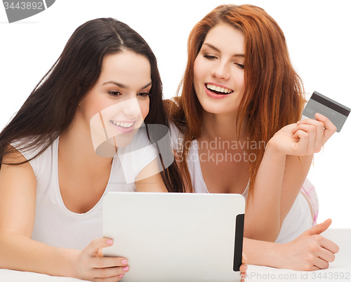 Image of smiling teenagers with tablet pc and credit card