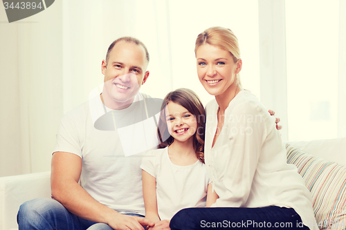 Image of smiling parents and little girl at home
