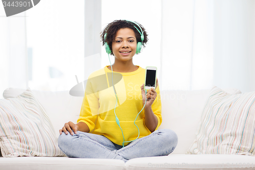 Image of happy african woman with smartphone and headphones