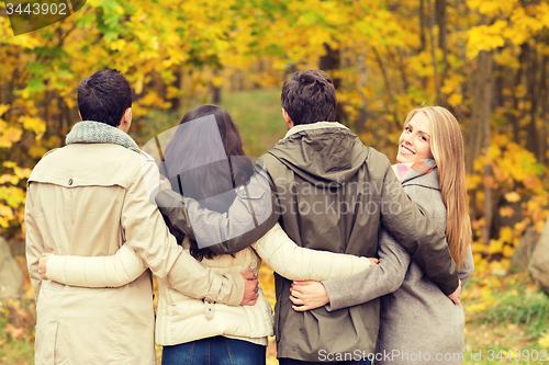 Image of group of smiling men and women in autumn park