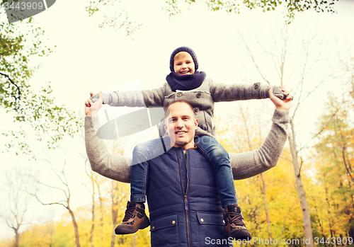 Image of happy family having fun in autumn park