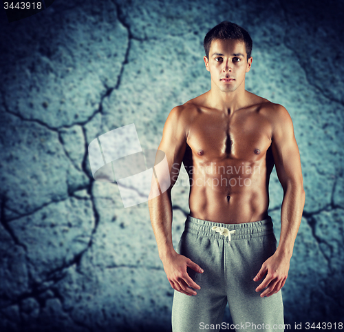 Image of young male bodybuilder with bare muscular torso