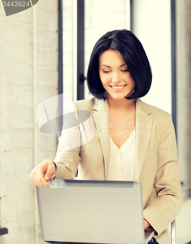 Image of happy woman with laptop computer and credit card