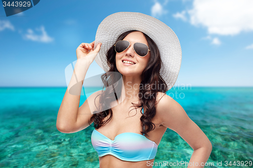 Image of happy young woman in bikini swimsuit and sun hat