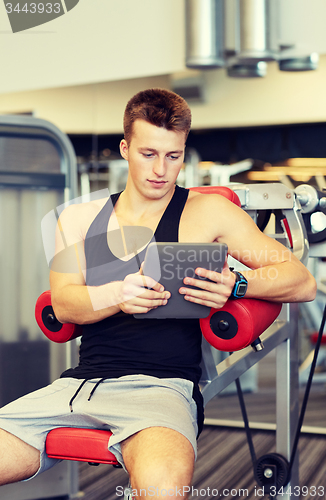 Image of young man with tablet pc computer in gym