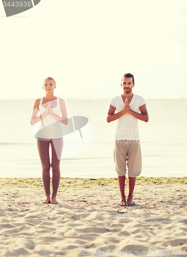 Image of couple making yoga exercises outdoors