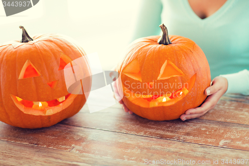 Image of close up of woman with pumpkins at home