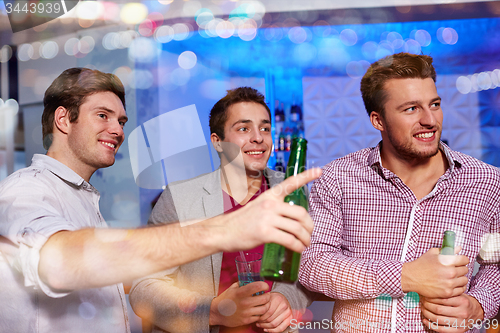 Image of group of male friends with beer in nightclub