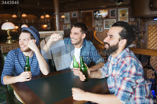 Image of happy male friends drinking beer at bar or pub