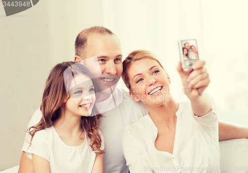 Image of happy family with little girl making self portrait
