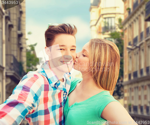 Image of happy couple taking selfie over city background