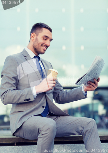 Image of young businessman with coffee and newspaper