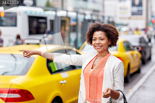 Image of happy african woman catching taxi