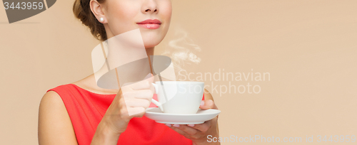 Image of smiling woman in red dress with cup of coffee