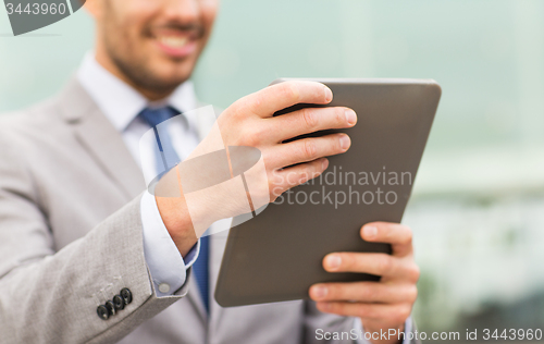 Image of close up of business man with tablet pc in city