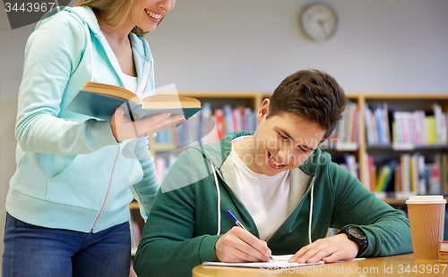 Image of happy students preparing to exams in library