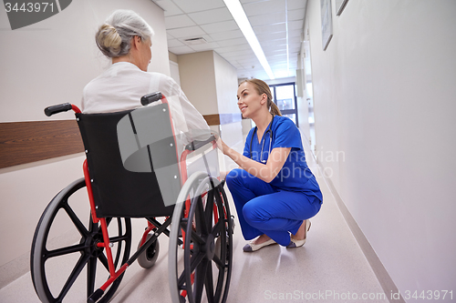 Image of nurse with senior woman in wheelchair at hospital