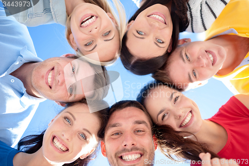 Image of smiling friends in circle on summer beach