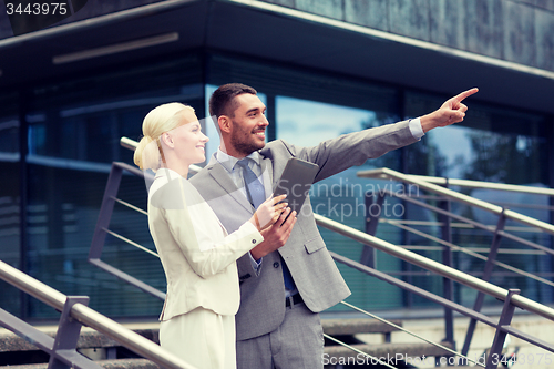 Image of smiling businessmen with tablet pc outdoors