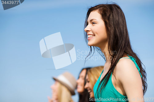 Image of girl with friends walking on the beach