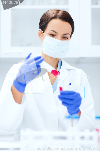 Image of close up of scientist holding test tube in lab