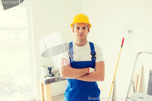 Image of builder in hardhat with working tools indoors