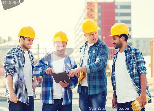 Image of group of smiling builders with tablet pc outdoors