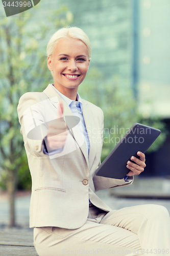 Image of smiling businesswoman with tablet pc outdoors