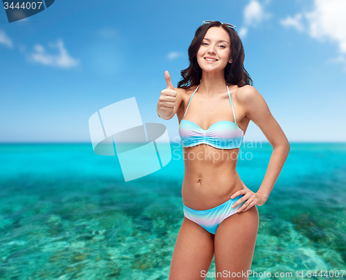 Image of happy woman in swimsuit showing thumbs up