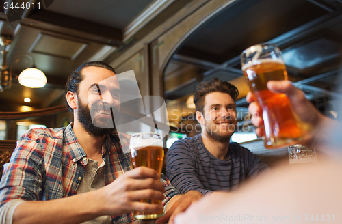 Image of happy male friends drinking beer at bar or pub