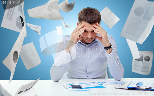 Image of close up of businessman with smartphone and papers