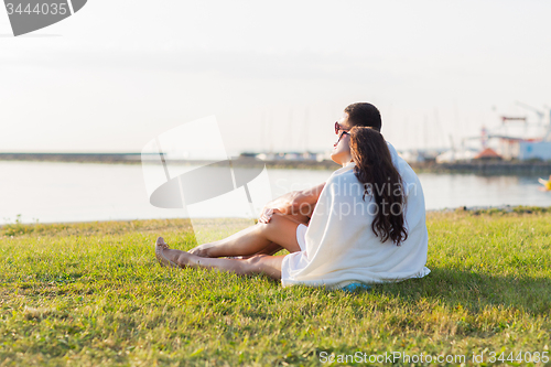 Image of close up of couple sitting on grass at seaside