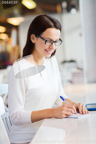 Image of smiling woman with tablet pc at cafe