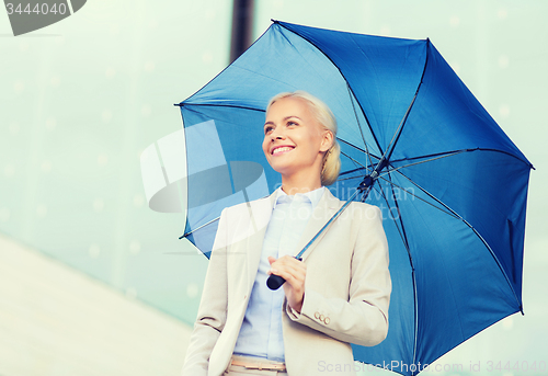 Image of young smiling businesswoman with umbrella outdoors