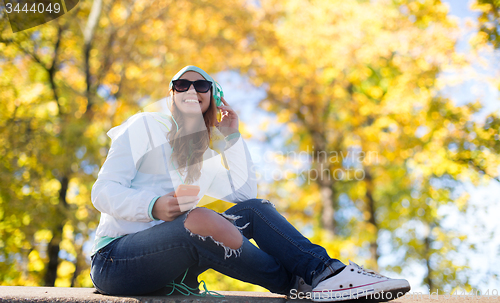 Image of happy young woman with smartphone and headphones