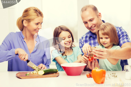 Image of happy family with two kids making dinner at home