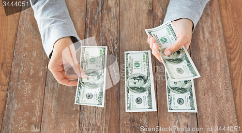 Image of close up of woman hands counting us dollar money