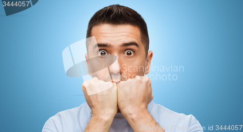 Image of scared man face over blue background