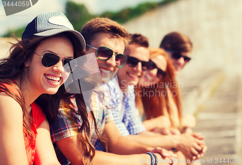 Image of close up of smiling friends sitting on city street